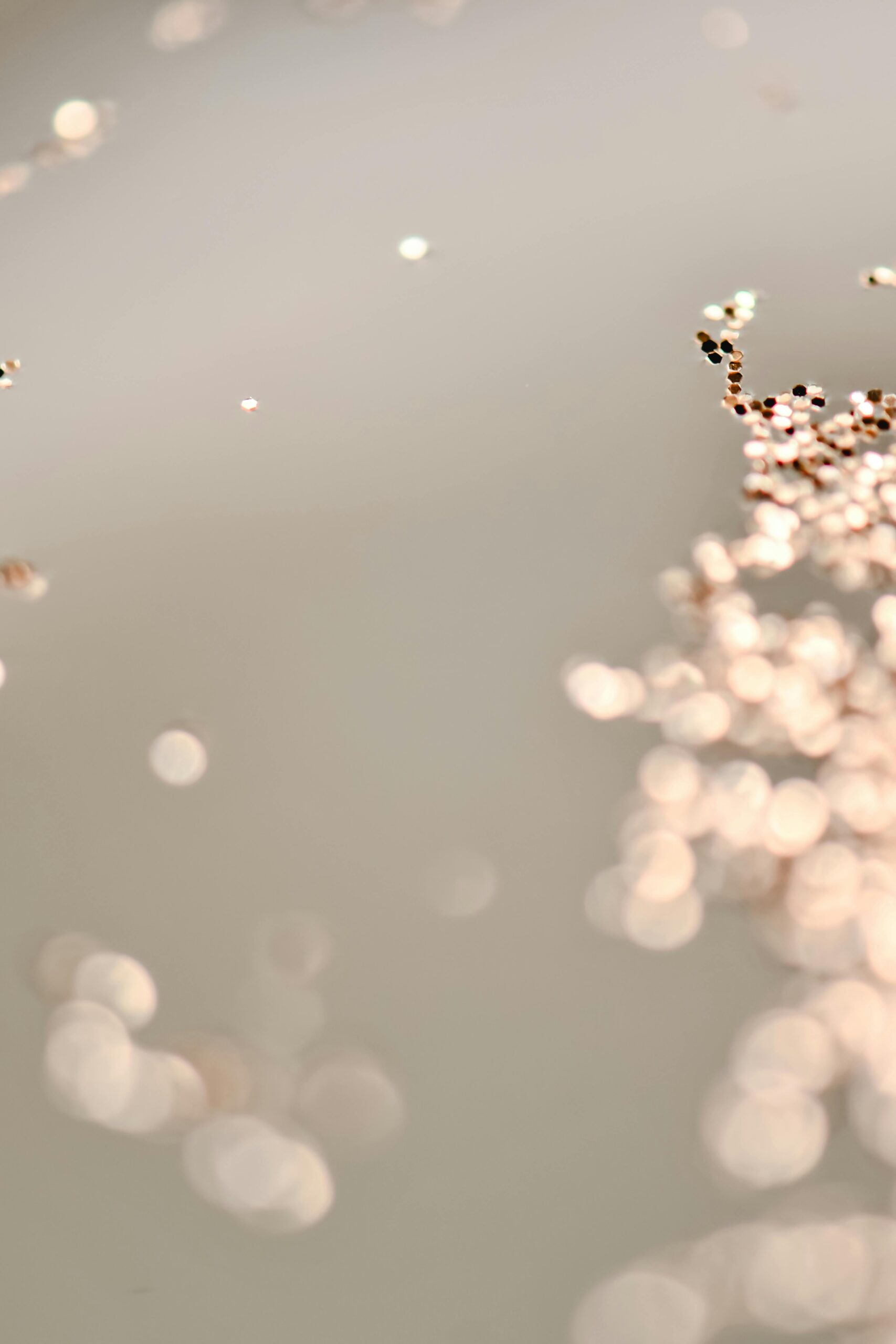 Close-up of soft sparkling glitter against a neutral background, creating a dreamy abstract texture.